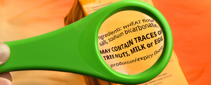 Reading ingredients on food package with magnifying glass