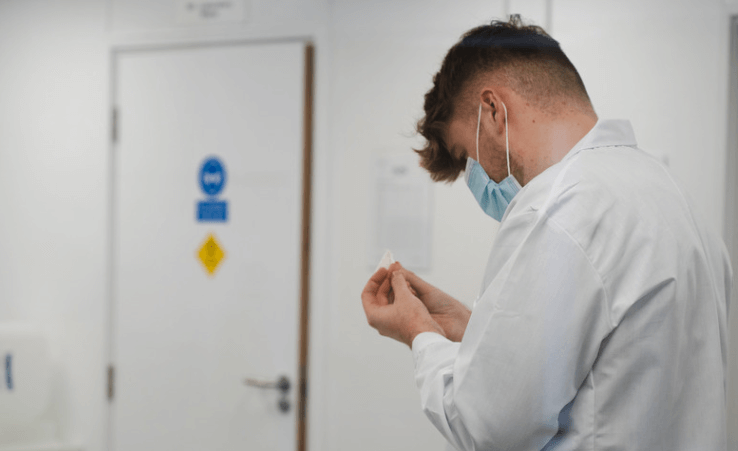 A young man cleaning his finger before taking a blood test