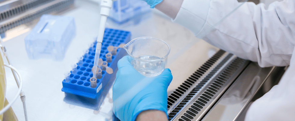 An image of a person filling vials with a solution