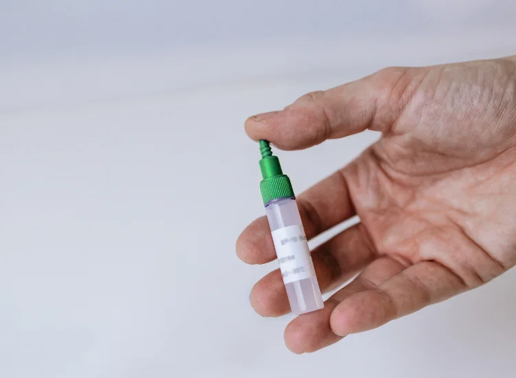 An image of a person shaking the sample collection tube